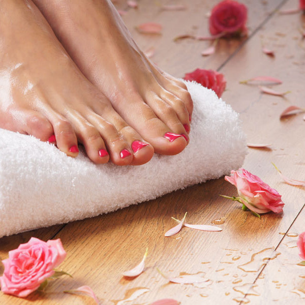 Picture of manicured feet on a towel with roses around them