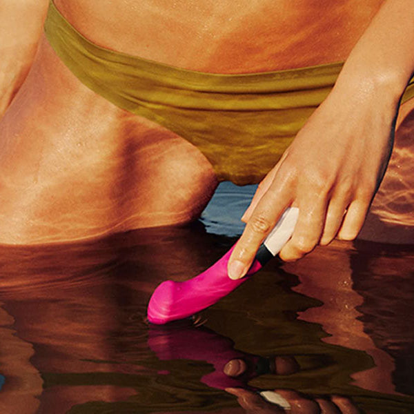 woman in pool holding lelo sex toy