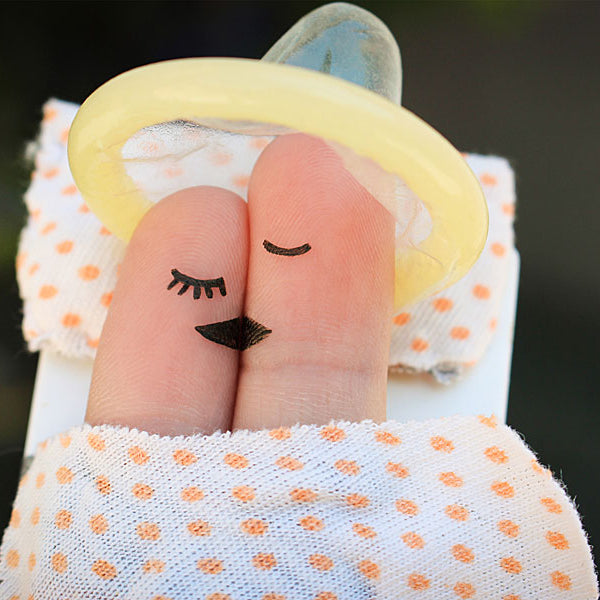 Mattress with finger puppet couple kissing and condom on their heads