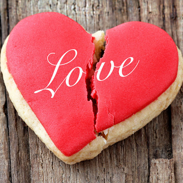 Broken heart cookie with love written on it.
