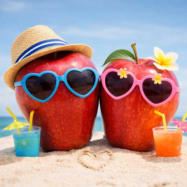 two apples as a couple posing on a beach for romantic picture
