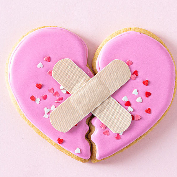 pink heart cookie broken with bandaids