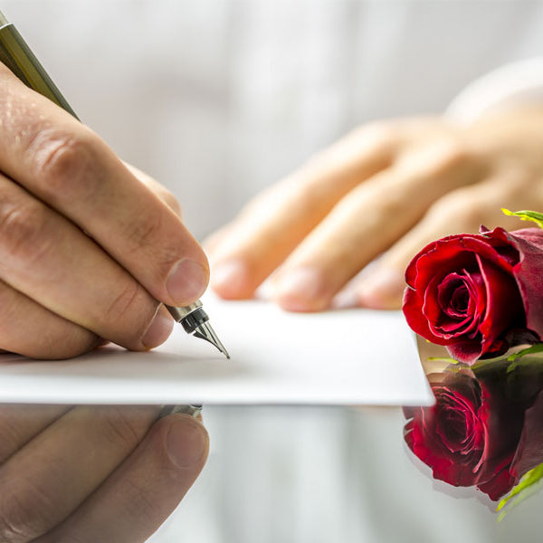 Man writing sex note with rose