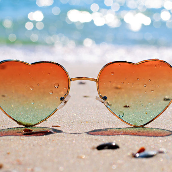 Heart shaped sunglasses on the beach