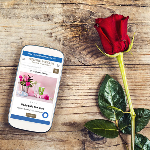 Cell phone on wooden table with rose