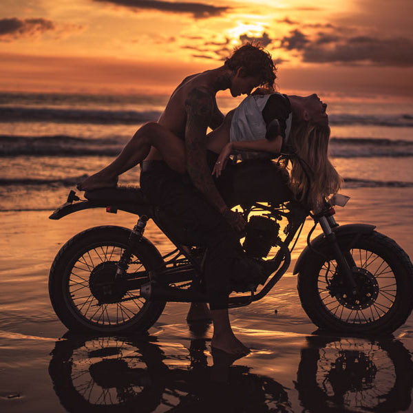 man kissing woman on motorcycle on beach, vacation sex story
