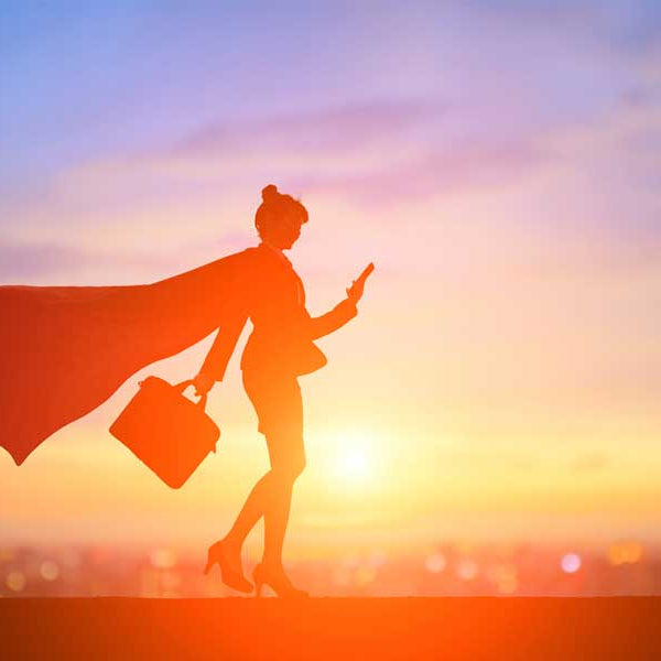 woman wearing a cape with a briefcase in hand